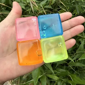 Set of four colorful square translucent squishy decompression toys held in hand