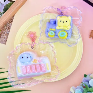 Close-up of handmade silicone squishy toys in cute train and piano shapes with packaging.