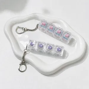 Detail view of a 4-key mechanical switch tester keychain with pink and purple accents