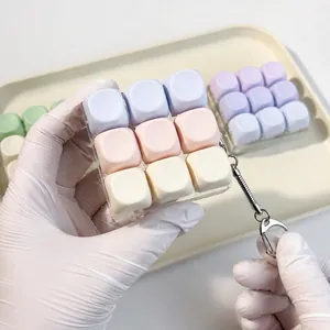Close-up of macaron 9-key mechanical switch tester fidget toy keychain held by hand.