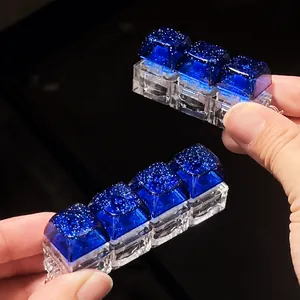 Close-up view of a four-key glowing blue galaxy mechanical keycap fidget keychain