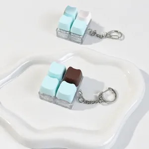 Close-up of cute cat-shaped chocolate keycap fidget toys on a white tray