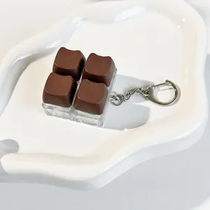 Close-up detail of a cute chocolate cat ear keycap fidget toy on a white ceramic plate