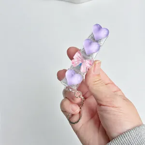 Macro view of heart-shaped keyboard switch tester keychain with pink bow ornament