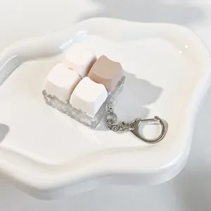 Macro view of a cute cat ear mechanical keycap fidget toy keychain on white tray