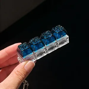 Macro view of a 4-key mechanical fidget keychain with glittering blue starry keycaps detail