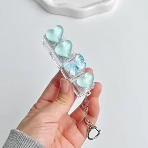 Close-up detail of ice-blue heart keycaps on a transparent fidget keypad toy keychain