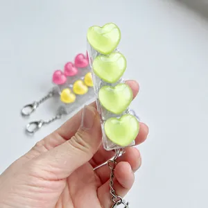 Close-up of a lime green icy translucent heart-shaped mechanical switch fidget toy keychain.
