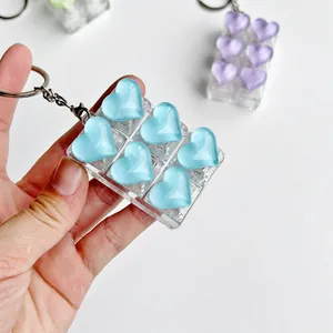 Detail view of a 6-grid heart-shaped resin fidget toy keychain with blue crystal finish