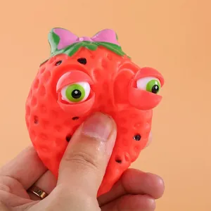 Funny strawberry squeeze toy with pop-out eyes for stress relief and sensory play.
