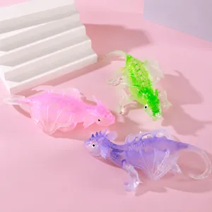 Close-up of three colorful translucent flying dragon fidget toys on pink background