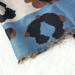 Primer plano de la suave textura y bordes deshilachados de una bufanda de leopardo azul.