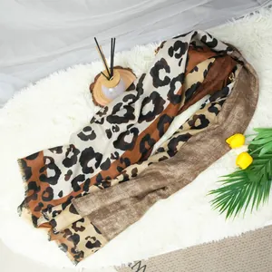 Primer plano de una bufanda larga con estampado de leopardo sobre una alfombra blanca