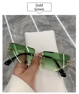 Trendy gold frame rimless rectangle sunglasses with green gradient lenses detail.