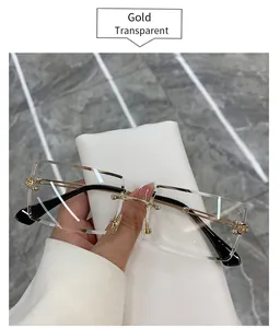 Close-up of rimless rectangular sunglasses with gold arms and transparent lenses