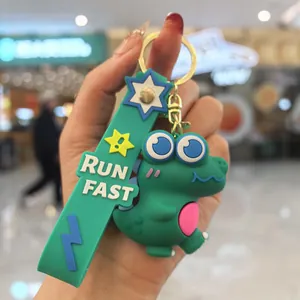 Détail d'un porte-clés dinosaure 3D vert mignon avec une dragonne marquée RUN FAST