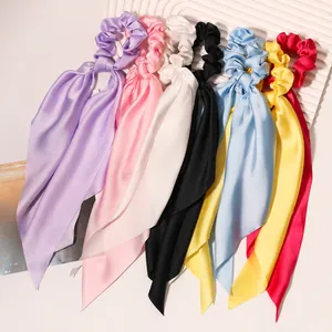 Detailed view of colorful satin scrunchies with elegant long ribbons for hair