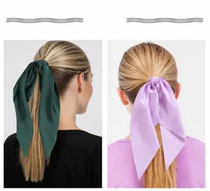 Two models showcasing elegant satin ribbon hair bows for ponytails in various colors