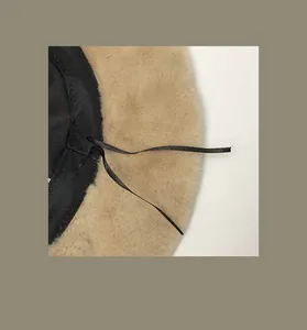 Detail view of the adjustable interior drawstring of a fuzzy khaki bucket hat