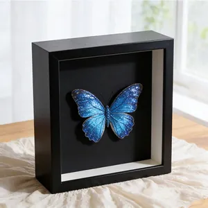 Detailansicht eines 3D-Schattenbox-Holzrahmens mit blauem Glitzer-Schmetterlingspräparat