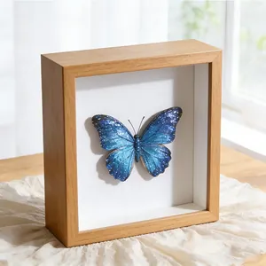 Nahaufnahme eines hölzernen 3D-Hohlrahmens mit einem leuchtend blauen Schmetterlingspräparat.