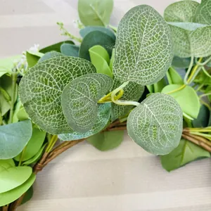 Primo piano di ghirlanda di eucalipto artificiale con foglie verdi e fiori bianchi