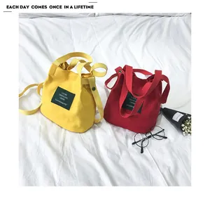 Close-up of yellow and red Japanese style canvas bucket bags with lifestyle accessories