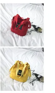 Macro view of red and yellow minimalist canvas bucket bags featuring functional shoulder straps