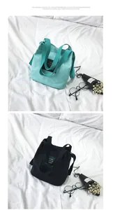 Details of minimalist canvas bucket bags in mint green and black with adjustable straps