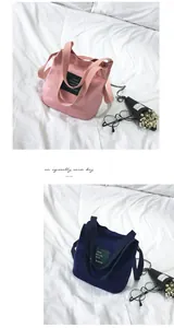 Macro view of minimalist pink and navy blue canvas bucket bags with lettered patch detail