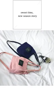 Minimalist pink and navy canvas bucket bags on white fabric background with dried flowers.