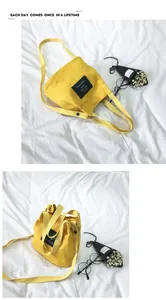 Yellow minimalist canvas bucket bag with adjustable shoulder strap and letter patch