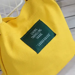 Minimalist yellow canvas bucket bag featuring a green letter patch in Japanese style