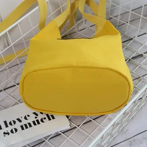 Bright yellow canvas bucket bag for women with versatile crossbody strap