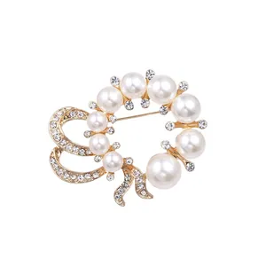 Elegant gold-tone wreath brooch with white pearls and sparkling crystals for weddings