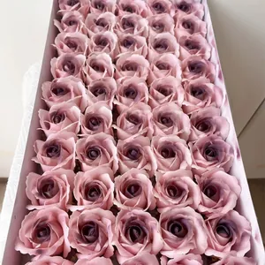 Primo piano di teste di rose di sapone rosa cipria disposte in una scatola da regalo bianca