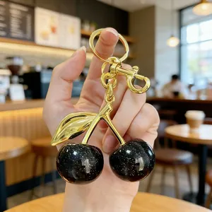 Elegant gold cherry keychain with black star-patterned pendants for bag decoration