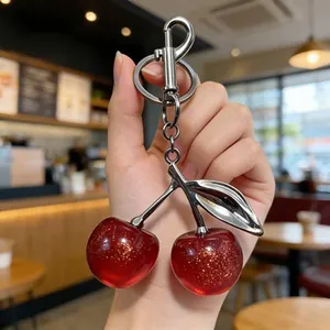 Exquisite cherry keychain bag charm with glittery red resin and silver metal leaf detail