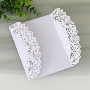 Detailed view of an elegant white laser-cut wedding invitation card with intricate floral lace