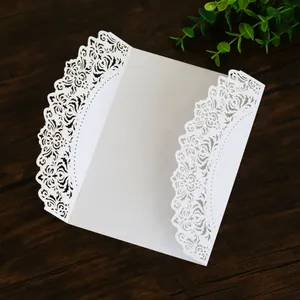 Macro view showing intricate laser-cut floral patterns on white wedding invitation card