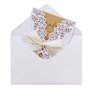 Detail view of white laser-cut wedding invitation set with cream ribbon and kraft insert.