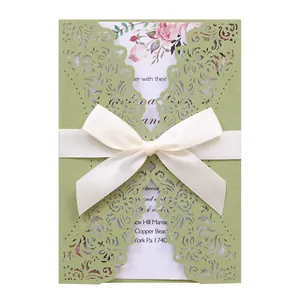 Elegant laser-cut green wedding invitation with white ribbon and floral inner card details.