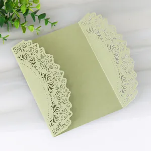 Detail view of light green laser cut wedding invitation card with lace pattern