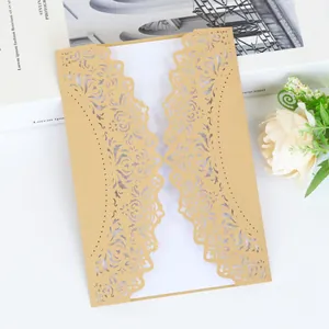 Close-up detail of an elegant gold laser-cut wedding invitation featuring intricate floral patterns