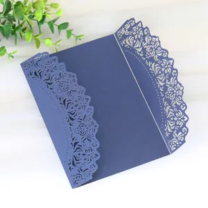 Detailed view of intricate navy blue laser-cut floral patterns on elegant wedding invitation
