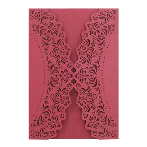 Close-up of elegant burgundy laser-cut lace pattern on a wedding invitation card