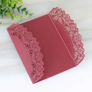 Close-up detail of a burgundy laser-cut wedding invitation card with floral patterns