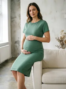 Vue détaillée d'une robe de maternité verte à manches courtes sur un mannequin enceinte.