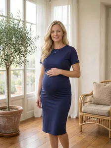 Robe de maternité élégante bleu marine à manches courtes dans un cadre domestique clair