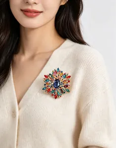 Vue détaillée d'une grande broche florale en cristal coloré sur un gilet de couleur crème